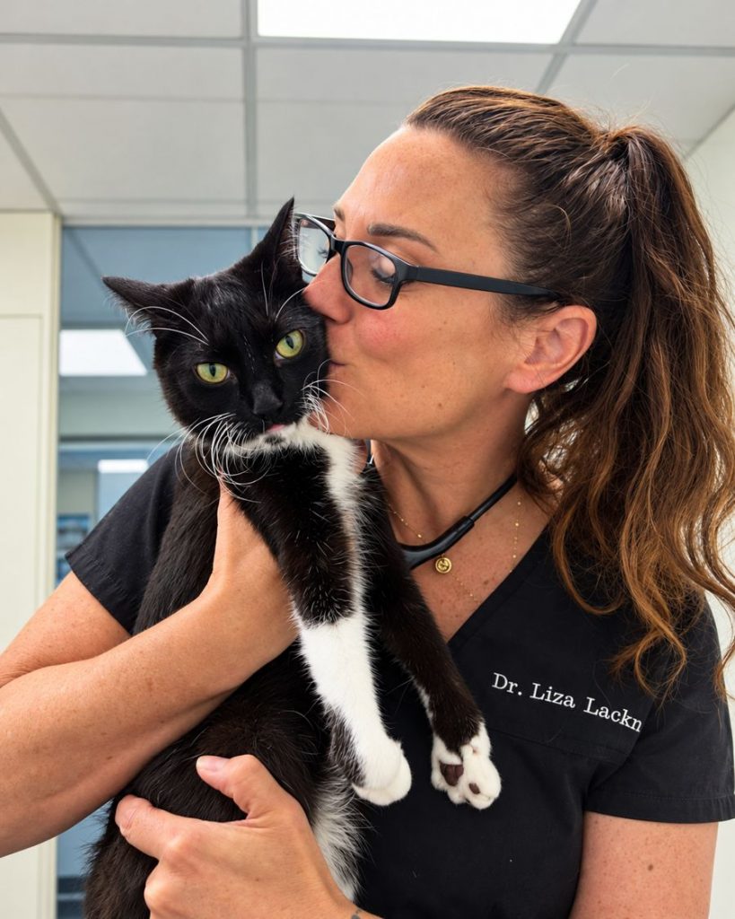 Dr. Liza Lackner kissing a black and white cat